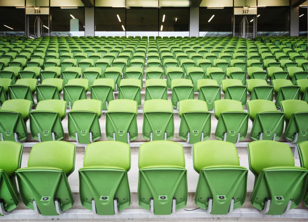 Clsoe up of green stadium chairs at a sports venue