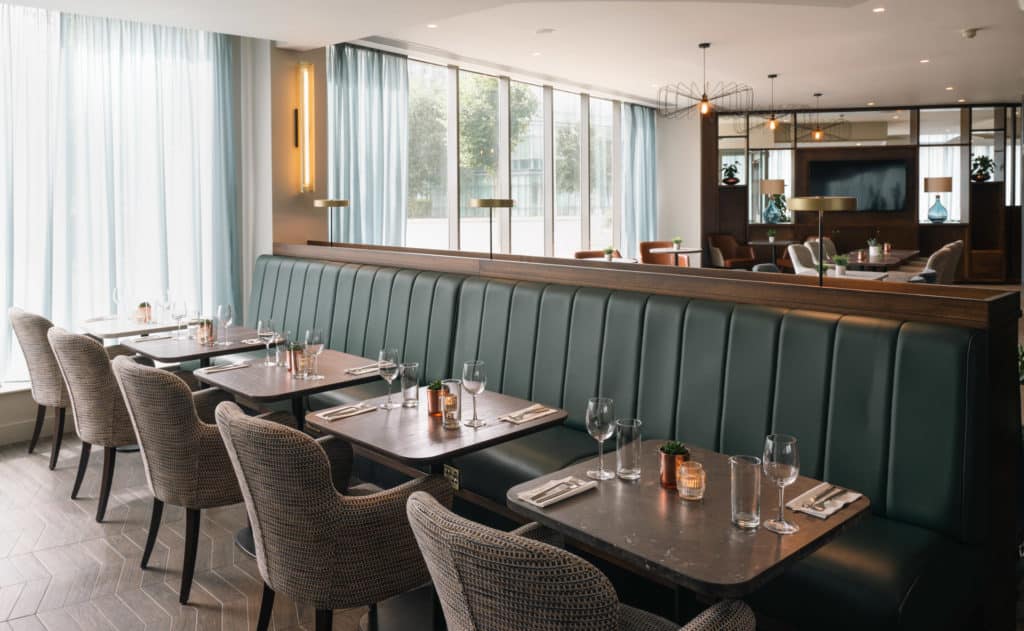 Aspect Hotel Park West Dining Area With Comfy Couches and tables set for dinner