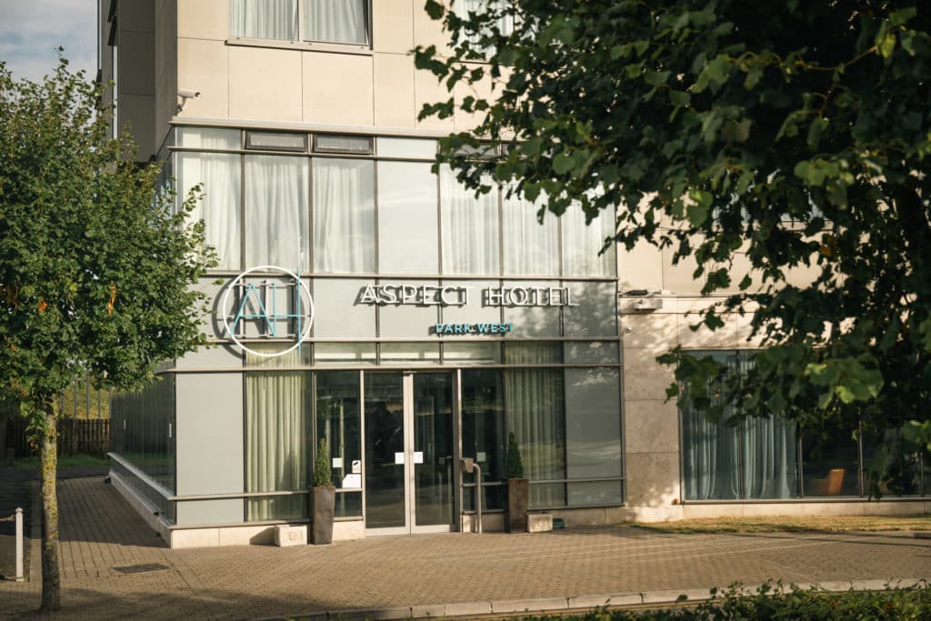 Exterior view of the entrance of Aspect Hotel Park West with parking