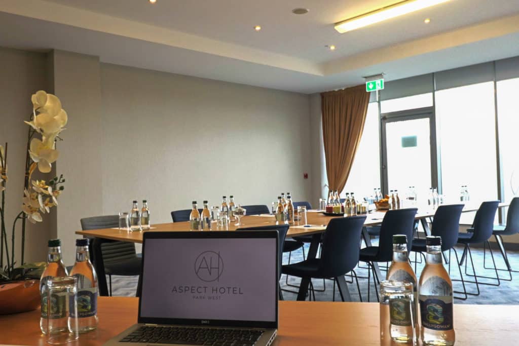 Aspect Hotel Park West Meeting Faciliator Table facing a large desk for delgates